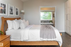 Hardwood flooring, built-in storage cabinetry, wall-mounted sconce, and a wood-finish bed frame - 