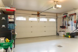 Garage with an overhead door featuring upper window panels, equipped with an automatic opener - 