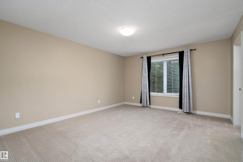 Spacious room with neutral-toned carpeting and walls - 11203 72 Avenue Nw, Edmonton, AB - Indoor Photo Showing Other Room