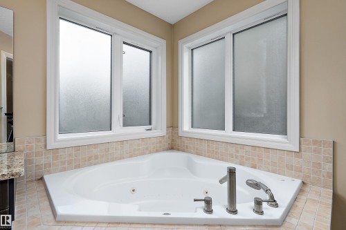 Corner soaking tub featuring brushed nickel fixtures - 11203 72 Avenue Nw, Edmonton, AB - Indoor Photo Showing Bathroom