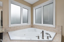 Corner soaking tub featuring brushed nickel fixtures - 