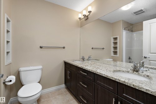 Bathroom featuring a dual-sink vanity with granite countertop and dark wood-finish cabinetry - 11203 72 Avenue Nw, Edmonton, AB - Indoor Photo Showing Bathroom