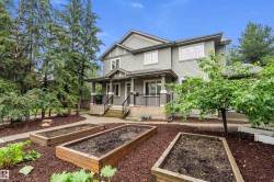 Two-story residence featuring light gray siding, white trim, and a covered porch with white columns - 