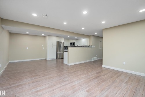 Open-concept living space featuring light wood-finish flooring, recessed ceiling lighting, and neutral wall tones - 11203 72 Avenue Nw, Edmonton, AB - Indoor
