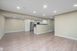 Open-concept living space featuring light wood-finish flooring, recessed ceiling lighting, and neutral wall tones - 