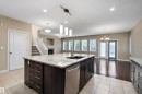 Kitchen featuring a large island with granite countertops, dark wood cabinetry, and a stainless steel dishwasher - 11203 72 Avenue Nw, Edmonton, AB  - Indoor Photo Showing Kitchen With Double Sink With Upgraded Kitchen 