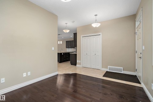 Rich wood-finish flooring extending from the entryway - 11203 72 Avenue Nw, Edmonton, AB - Indoor Photo Showing Other Room