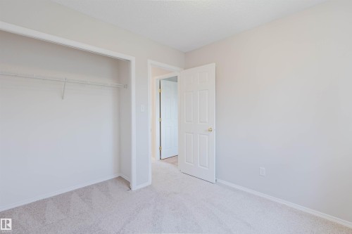 Plush carpet flooring, neutral wall paint, white trim, and a closet with a wire rack - 21332 89 Avenue Nw, Edmonton, AB - Indoor Photo Showing Other Room