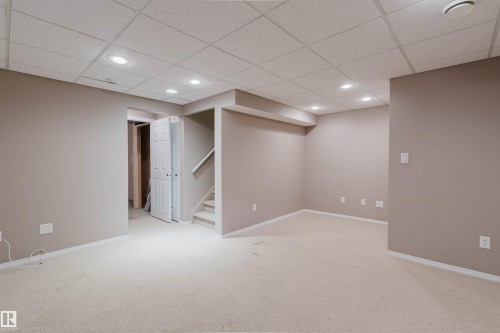 Recessed lighting illuminates this carpeted lower level, featuring a drop ceiling and warm neutral wall tones - 21332 89 Avenue Nw, Edmonton, AB - Indoor Photo Showing Other Room
