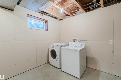 Daylight window with privacy screen, concrete flooring, and exposed ceiling joists - 21332 89 Avenue Nw, Edmonton, AB - Indoor Photo Showing Laundry Room