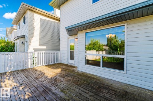 Expansive wood deck with white railing, large exterior window, and white vinyl siding - 21332 89 Avenue Nw, Edmonton, AB - Outdoor With Deck Patio Veranda With Exterior