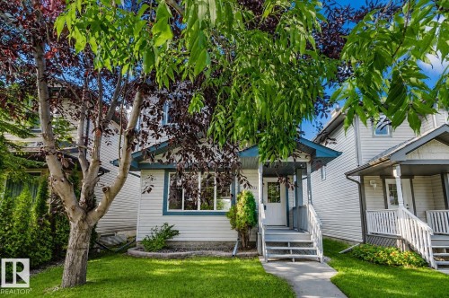 White siding exterior with a covered front porch, grey railings, and a concrete pathway - 21332 89 Avenue Nw, Edmonton, AB - Outdoor