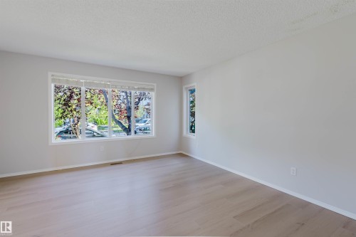 Hardwood-finish flooring, white trim, and multiple windows - 21332 89 Avenue Nw, Edmonton, AB - Indoor Photo Showing Other Room
