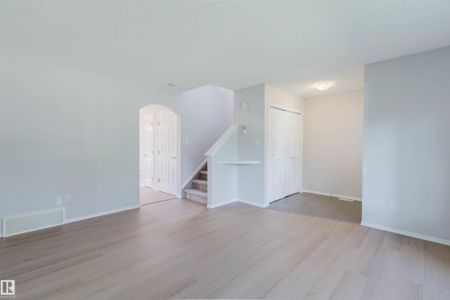 Wood-finish flooring, light grey wall paint, and white trim - 21332 89 Avenue Nw, Edmonton, AB - Indoor Photo Showing Other Room