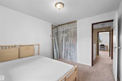 Wall-to-wall carpeting and white walls with a built-in closet featuring mirrored doors - 