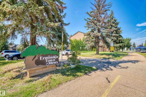 Erminskin Town Mews signage with mature trees and a paved pathway - 2730 105 Street Nw, Edmonton, AB - Outdoor