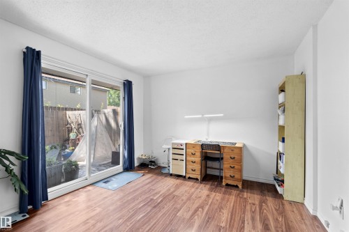 Wood-finish flooring, white walls, and a sliding glass door to an outdoor area - 2730 105 Street Nw, Edmonton, AB - Indoor