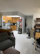 Kitchen with wood-finish cabinetry, stainless steel appliances, and a granite-look island - 