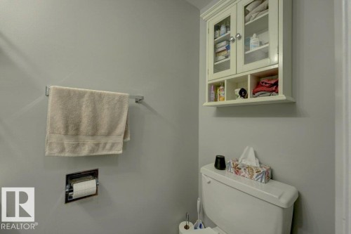 Wall-mounted cabinet with glass-front doors and open shelving - 307 Northgate Terrace Nw, Edmonton, AB - Indoor Photo Showing Bathroom