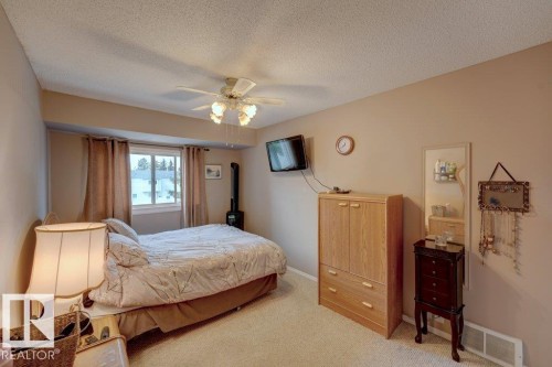 Recessed window with drapes, wall-mounted television, and ceiling fan with light fixture - 307 Northgate Terrace Nw, Edmonton, AB - Indoor Photo Showing Bedroom