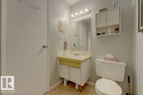 Vanity with integrated sink, mounted mirror, overhead lighting, and wall-mounted storage cabinet - 307 Northgate Terrace Nw, Edmonton, AB - Indoor Photo Showing Bathroom