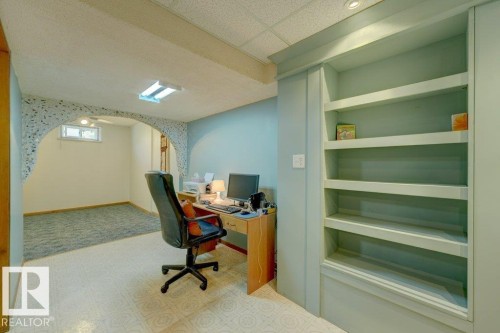 Built-in shelving unit with a recessed ceiling light, arched wall opening, and patterned flooring - 307 Northgate Terrace Nw, Edmonton, AB - Indoor Photo Showing Office