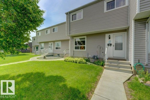 Gray siding exterior with white trim, concrete walkway, front entrance with an exterior light fixture, white door, and white handrails - 307 Northgate Terrace Nw, Edmonton, AB - Outdoor