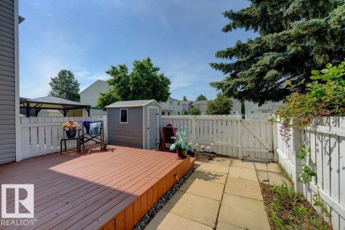 Spacious wood-finish deck with a white picket fence, a storage shed, and a paved patio area - 307 Northgate Terrace Nw, Edmonton, AB - Outdoor With Deck Patio Veranda With Exterior