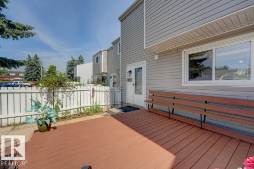 Expansive wood-finish deck with a built-in bench, white picket fence, and a private entry door - 307 Northgate Terrace Nw, Edmonton, AB - Outdoor With Deck Patio Veranda With Exterior
