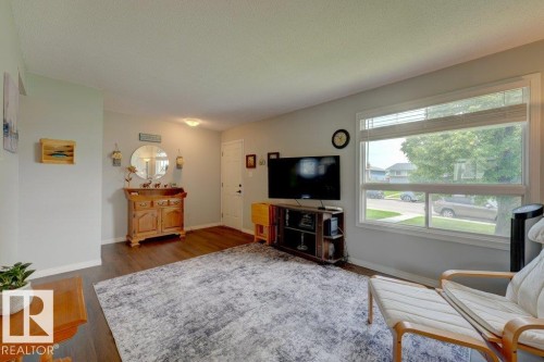 Wood-finish flooring throughout, featuring a large window with blinds, and white painted walls - 307 Northgate Terrace Nw, Edmonton, AB - Indoor Photo Showing Living Room