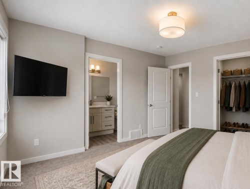 Wall-mounted television with a window, ceiling-mounted light fixture, and carpeted flooring - 2355 Kelly Circle Circle Sw, Edmonton, AB - Indoor Photo Showing Bedroom
