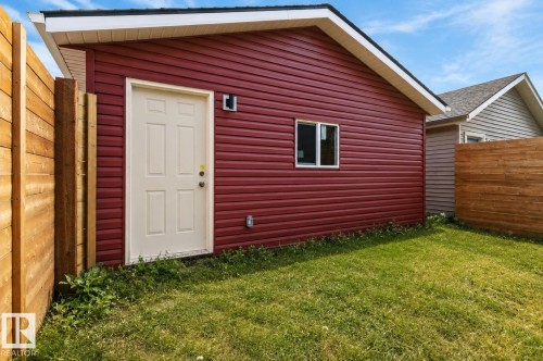 Red siding structure with white trim, a side entry door, and a single window - 2355 Kelly Circle Circle Sw, Edmonton, AB - Outdoor With Exterior