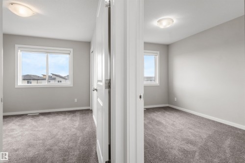 Neutral gray walls, gray carpeting, dual pane windows, and flush-mount ceiling lights - 2355 Kelly Circle Circle Sw, Edmonton, AB - Indoor Photo Showing Other Room