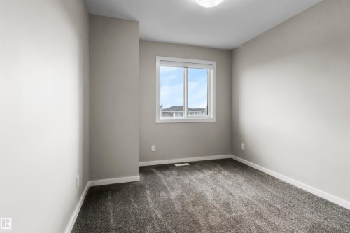Neutral wall tones complement the durable carpet flooring - 2355 Kelly Circle Circle Sw, Edmonton, AB - Indoor Photo Showing Other Room