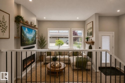 Built-in electric fireplace, recessed lighting, wood-finish flooring, multiple windows, and a glass-paneled door - 2355 Kelly Circle Circle Sw, Edmonton, AB - Indoor Photo Showing Other Room