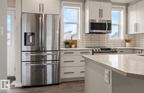 Stainless steel French door refrigerator, built-in microwave, and range - 2355 Kelly Circle Circle Sw, Edmonton, AB - Indoor Photo Showing Kitchen With Stainless Steel Kitchen With Upgraded Kitchen