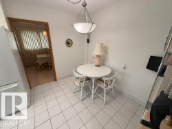 Kitchenette area featuring white square tile flooring and a central pendant light fixture - 