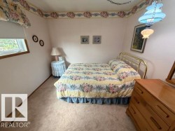 Carpeted interior space featuring a window with wood trim, a decorative ceiling light fixture, and a wallpaper border - 