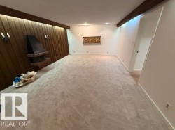 Spacious room featuring a prominent wood-paneled accent wall with integrated ambient lighting - 