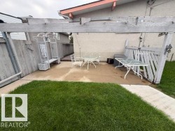 Outdoor patio featuring a concrete surface and a wooden pergola structure - 