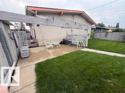 Private backyard featuring a concrete patio, wood fence, and well-maintained lawn - 6824 89 Avenue Nw, Edmonton, AB - Outdoor