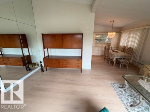 Light wood-finish flooring extending through living and dining areas - 6824 89 Avenue Nw, Edmonton, AB - Indoor