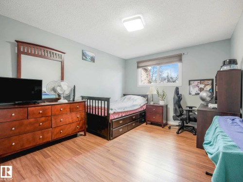 Light-toned interior walls featuring wood-finish flooring - 13405 40 St Nw, Edmonton, AB - Indoor Photo Showing Bedroom