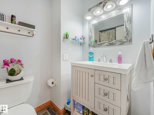 Bathroom featuring a white vanity with integrated sink, chrome-finish faucet, and coordinating hardware - 13405 40 St Nw, Edmonton, AB - Indoor Photo Showing Bathroom