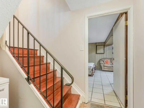 Staircase with wood-finish treads and a metal handrail - 13405 40 St Nw, Edmonton, AB - Indoor Photo Showing Other Room