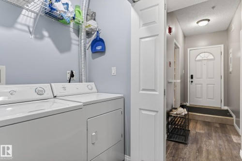 Dedicated laundry area with washer and dryer, complemented by wire shelving - #103 8108 109 St Nw, Edmonton, AB 