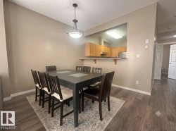 Wood-finish flooring throughout, with a pass-through window and a built-in breakfast bar in the kitchen - 