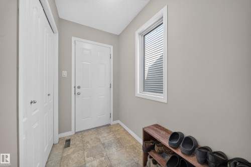 Front entry with durable tile flooring and a white paneled door - 1927 51 Street Sw, Edmonton, AB - Indoor Photo Showing Other Room