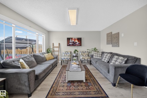 Wood-finish flooring, recessed lighting, and expansive windows - 1927 51 Street Sw, Edmonton, AB - Indoor Photo Showing Living Room