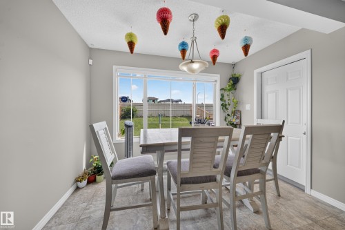 Recessed lighting, wood-finish flooring, white paneled door, and a large window - 1927 51 Street Sw, Edmonton, AB - Indoor Photo Showing Dining Room